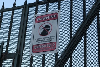 Neighborhood watch sign on a gate