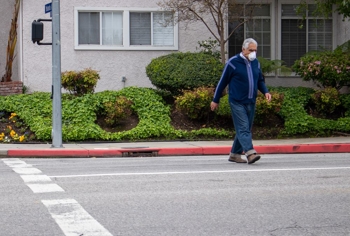 Man with a mask crossing the street