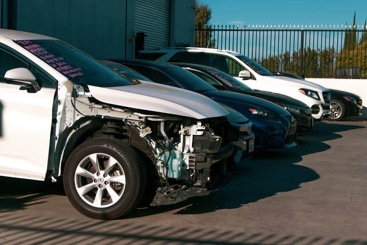 A line of cars with the first car damaged after a car accident