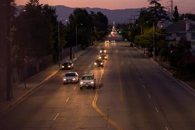 Cars driving down a road at dusk