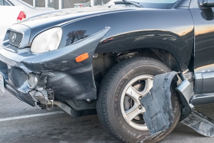 A black car with damage after a car accident